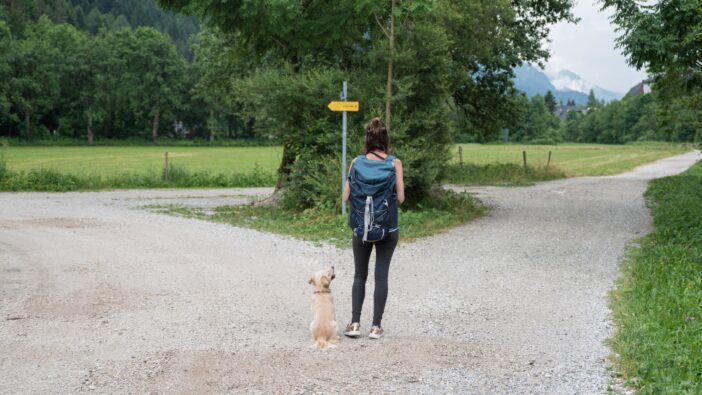 woman and dog trying to decide which path to take