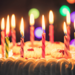 photo of birthday cake with candles lit