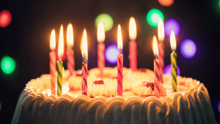 photo of birthday cake with candles lit