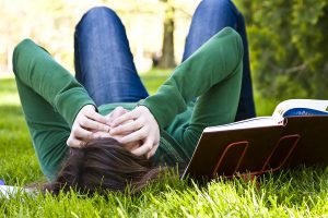 Exhausted student over the grass in the park